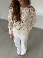 Modelfoto af pige som bærer hvid DOLLY bluse med storblomstret mønster, samt hvide jeans. Alt er fra BySofieSønderby