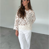 Modelfoto af pige som bærer hvid DOLLY bluse med storblomstret mønster, samt hvide jeans. Alt er fra BySofieSønderby