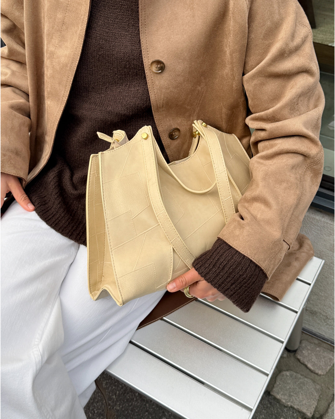 Modelbillede af pige der holder cremefarvet ELINA taske. Fra BySofieSønderby.