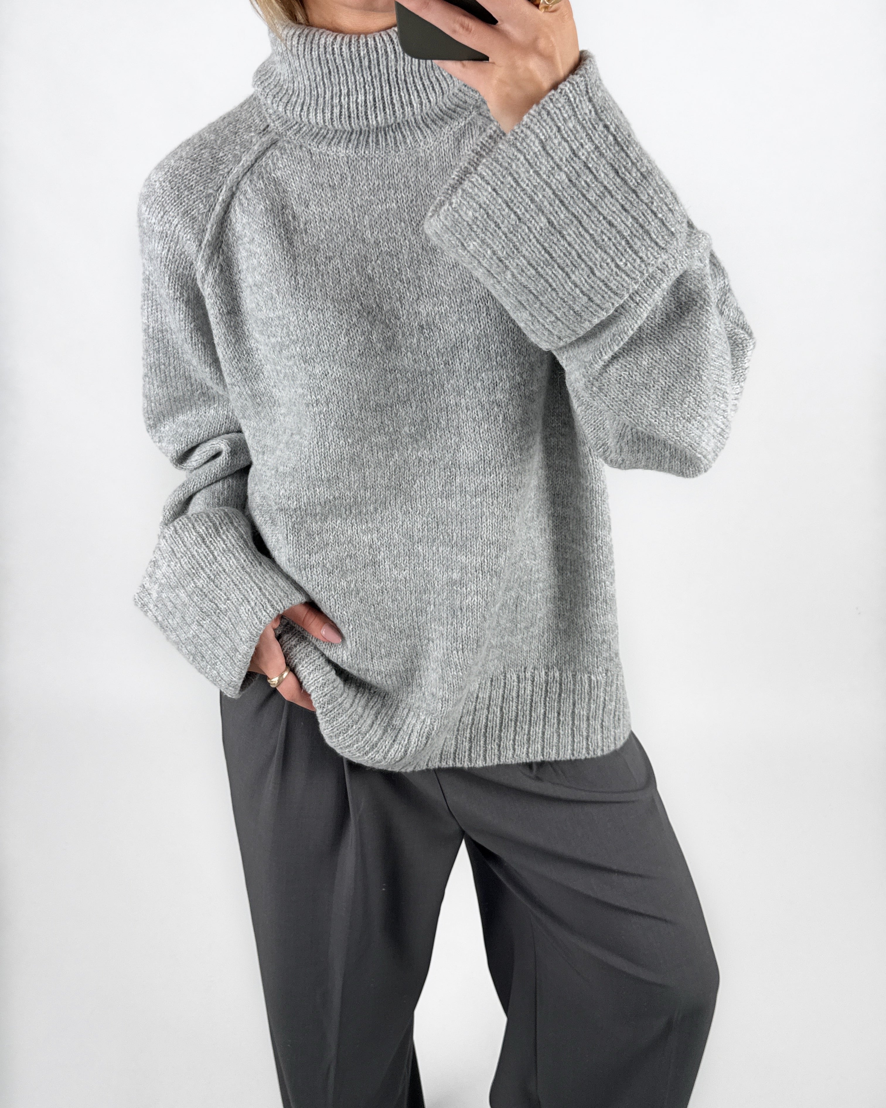 Modelfoto af pige i grå ELLINORA striktrøje med rullekrave, samt grå LISA bukser. Alt er fra BySofieSønderby.