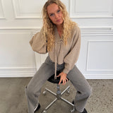 Modelfoto af pige i beige ELLIOT cardigan, samt grå NANNA jeans. Alt er fra BySofieSønderby.