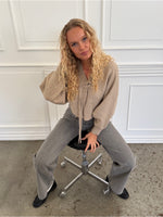 Modelfoto af pige i beige ELLIOT cardigan, samt grå NANNA jeans. Alt er fra BySofieSønderby.