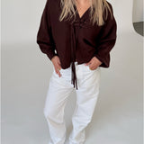 Modelfoto af pige i brun ELLIOT cardigan, samt hvide NANNA jeans. Alt er fra BySofieSønderby.