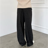 Modelfoto af pige i sort melerede ELLIS bukser, samt beige striktrøje. Alt er fra BySofieSønderby.