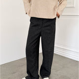 Modelfoto af pige i sort melerede ELLIS bukser, samt beige striktrøje. Alt er fra BySofieSønderby.