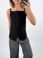 Modelfoto af pige med sort ELLIS top med stropper og knapper, samt grå MILAN bukser. Set forfra. Alt er fra BySofieSønderby