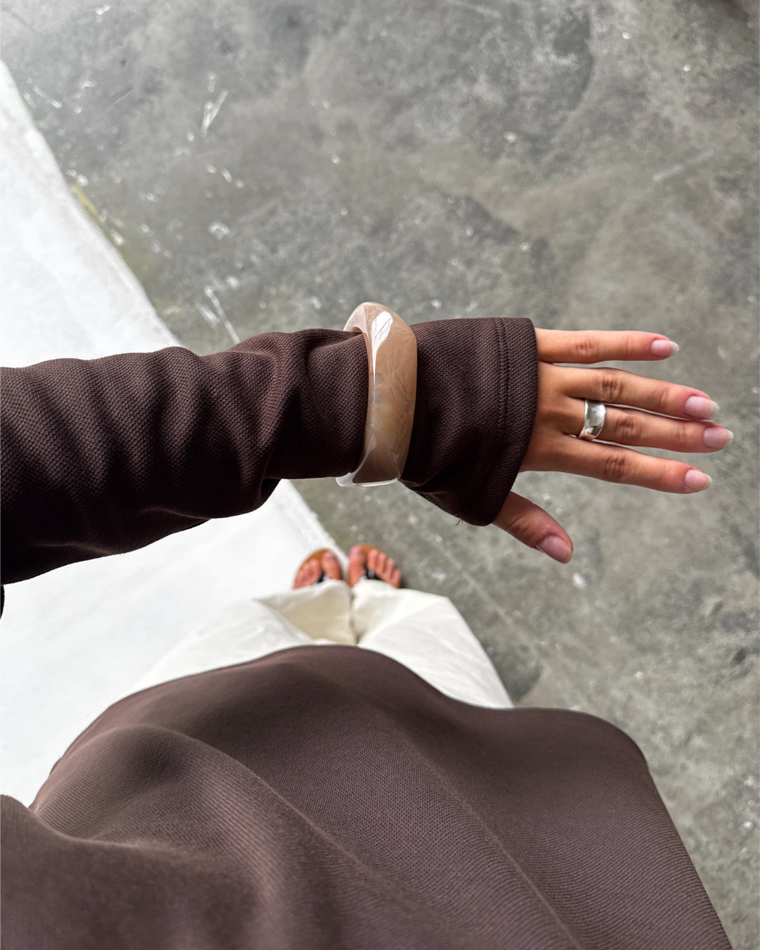 Modelfoto af en Emberly bangle armbånd brun. Baggrund er grå. Fra BySofieSønderby