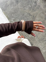Modelfoto af en Emberly bangle armbånd brun. Baggrund er grå. Fra BySofieSønderby