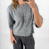 Modelfoto af pige i grå EVI strik t-shirt med knapper og grå LISA bukser. Alt er fra BySofieSønderby.