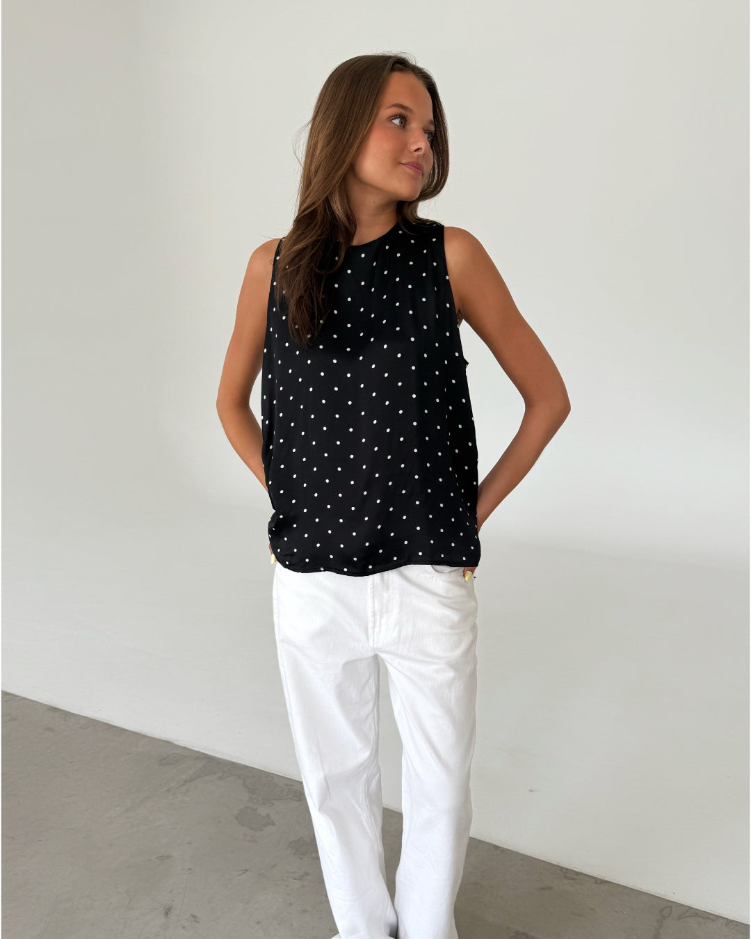 Modelfoto af pige med FANNY top, sort og NANNA bukser, hvid - begge fra fra BySofieSønderby