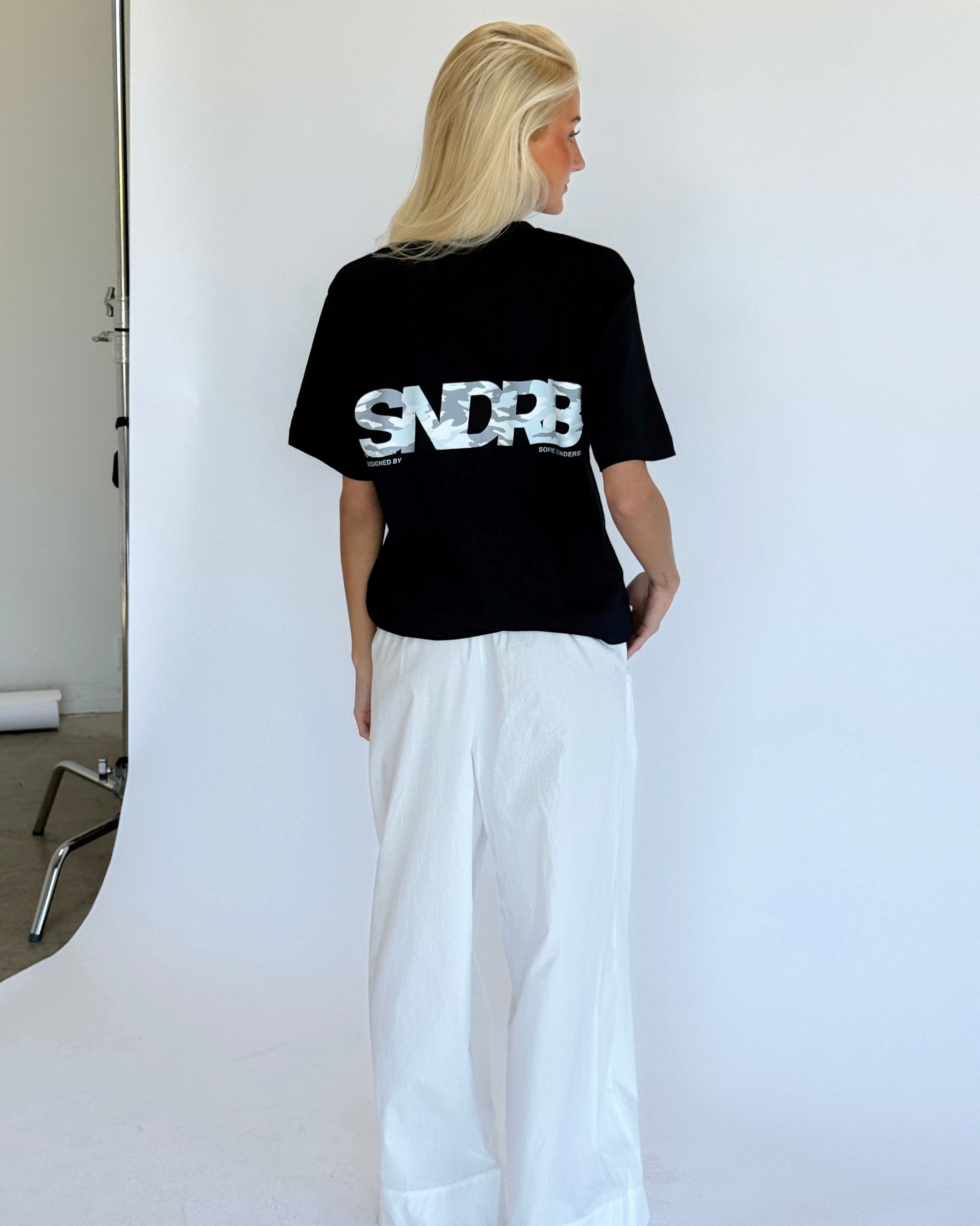 Modelbillede af navy SNDRB t-shirt med grå camouflage tryk. Set bagfra. Fra BySofieSønderby