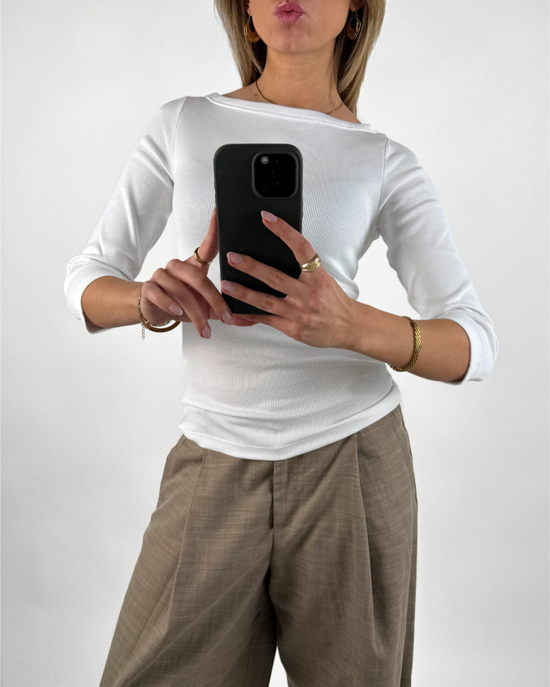 Stemningsbillede af pige der bærer en hvid FIFI boatneck bluse, samt beige MONI bukser.  Fra BySofieSønderby