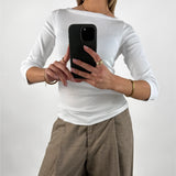 Stemningsbillede af pige der bærer en hvid FIFI boatneck bluse, samt beige MONI bukser.  Fra BySofieSønderby