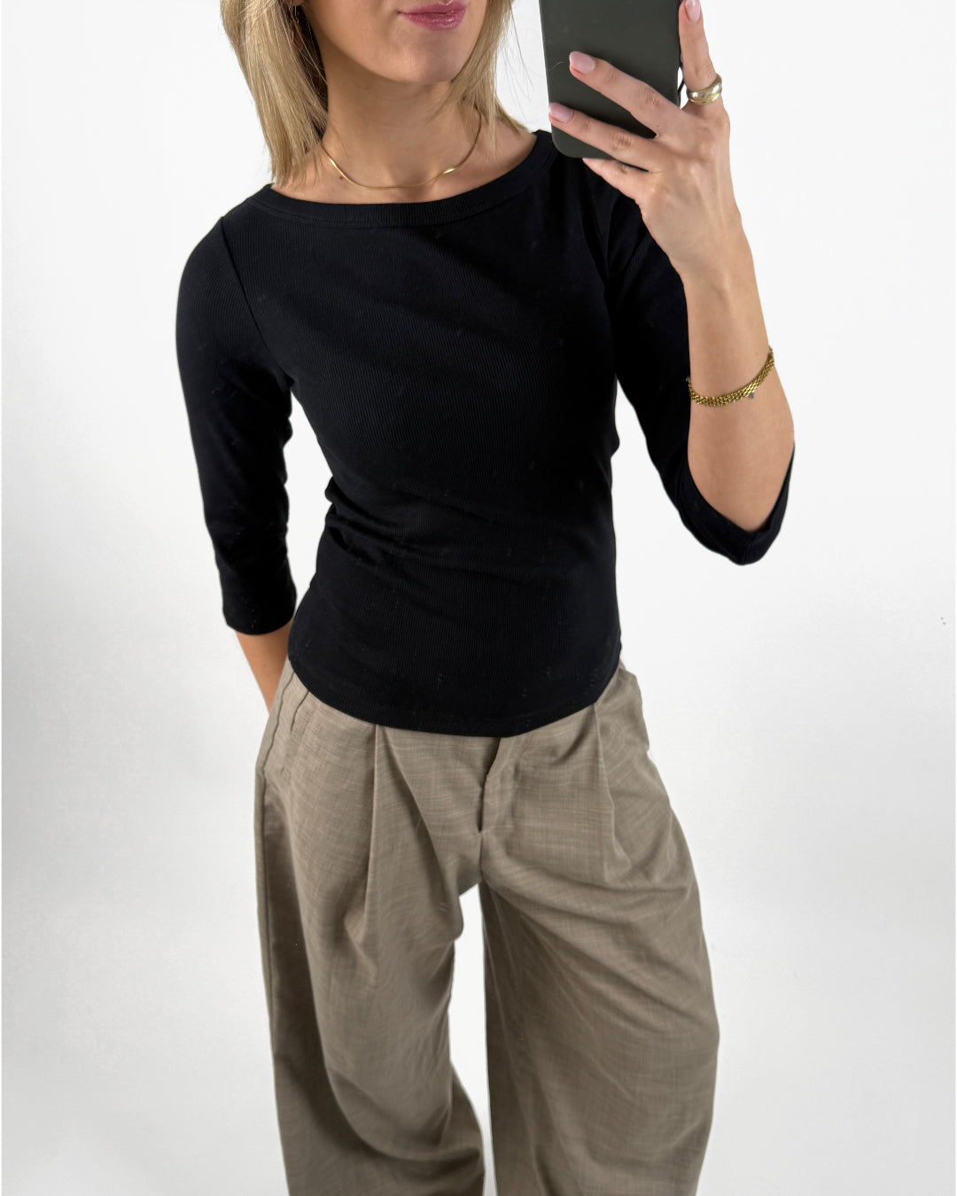 Stemningsbillede af pige der bærer en sort FIFI boatneck bluse, samt beige MONI bukser.  Fra BySofieSønderby