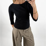 Stemningsbillede af pige der bærer en sort FIFI boatneck bluse, samt beige MONI bukser.  Fra BySofieSønderby