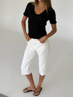 Modelbillede af FINLEY strik t-shirt, sort og VANESSA capri bukser, hvid. Fra BySofieSønderby