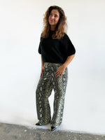 Modelfoto af pige i Gelly bukser med slangeprint og sort Poppy strik t-shirt. Alt er fra BySofieSønderby