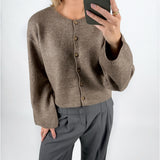 Modelfoto af pige i brun HADLEE cardigan, og grå LISA bukser. Alt er fra BySofieSønderby.