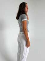 Modelfoto af pige som bærer en Henna t-shirt i grå, samt hvide Nanna jeans. Alt fra By Sofie Sønderby
