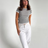 Modelfoto af pige som bærer en Henna t-shirt i grå, samt hvide Nanna jeans. Alt fra By Sofie Sønderby