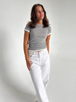 Modelfoto af pige som bærer en Henna t-shirt i grå, samt hvide Nanna jeans. Alt fra By Sofie Sønderby