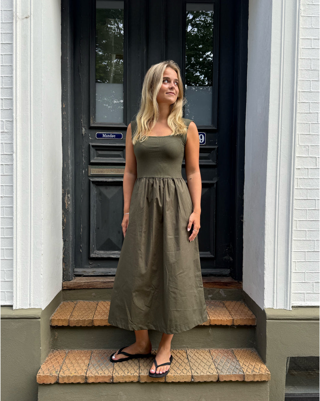 Modelfoto af pige, som bærer SIMONE kjole, kaki og sandal, sort - alt fra BySofieSønderby.