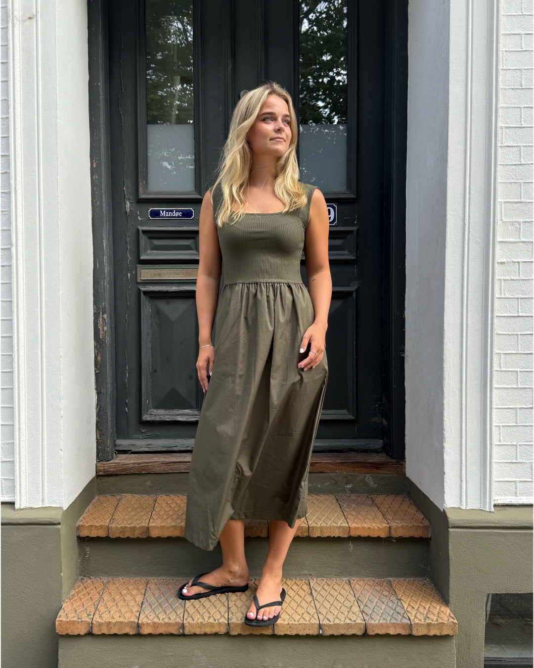 Modelfoto af pige, som bærer SIMONE kjole, kaki og sandal, sort - alt fra BySofieSønderby.