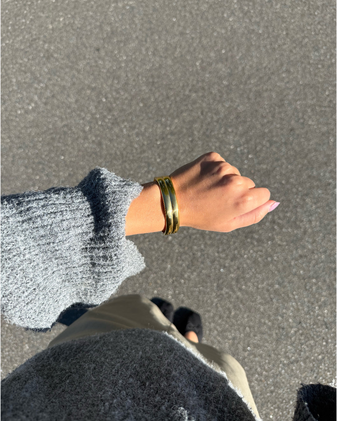 Modelfoto af en Jazlyn guld armbånd. Baggrund er grå. Fra BySofieSønderby