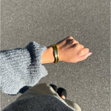 Modelfoto af en Jazlyn guld armbånd. Baggrund er grå. Fra BySofieSønderby