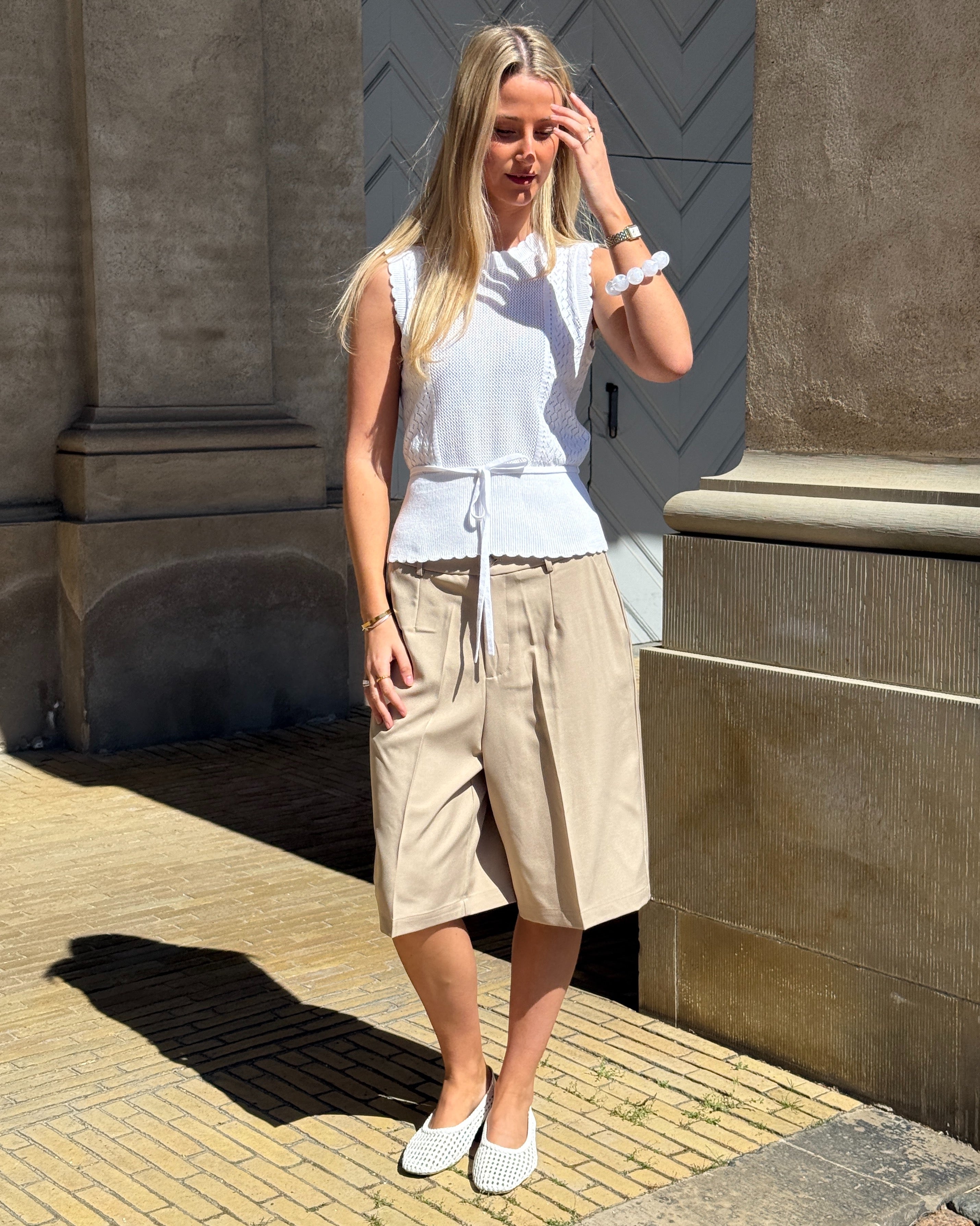 Modelbillede af JEANY strik top, hvid og HARLEE shorts, beige. Fra BySofieSønderby