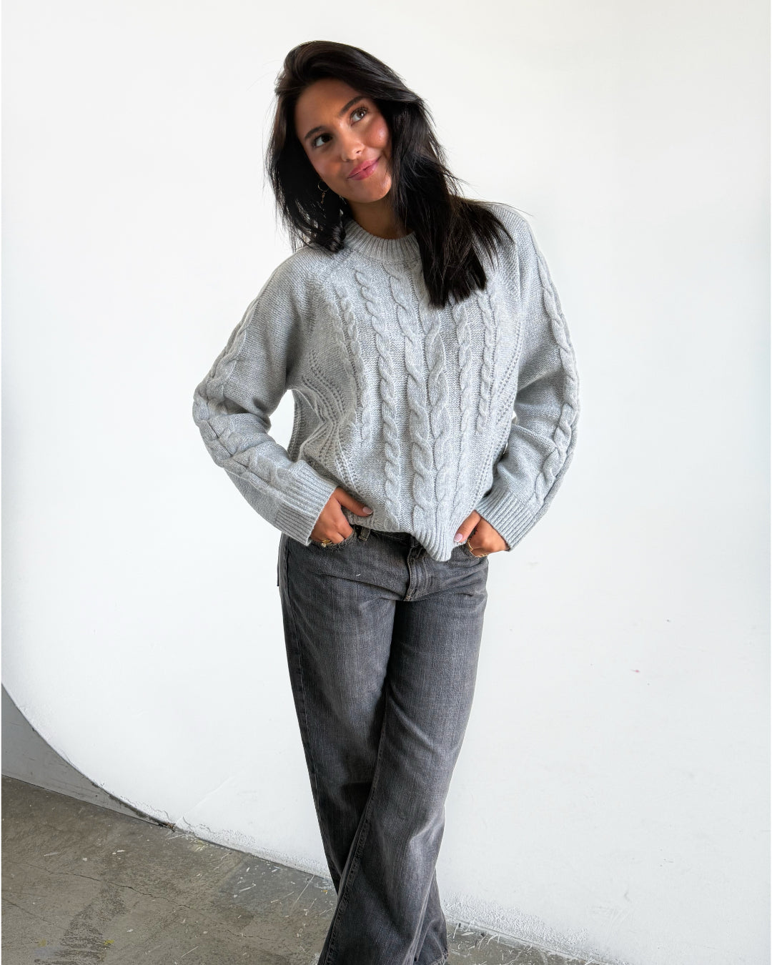 Modelfoto af pige i grå Josie striktrøje, og grå Nanna jeans. Alt er fra BySofieSønderby 