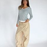 Modelbillede af KAIA langærmet v-hals, grå og DANIA wide leg bukser, beige. Begge fra BySofieSønderby