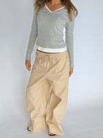 Modelbillede af KAIA langærmet v-hals, grå og DANIA wide leg bukser, beige. Begge fra BySofieSønderby