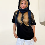Modelfoto af pige iført navy KATHERINE balaclava, mørkblå t-shirt og hvide NANNA jeans. Alt er fra BySofieSønderby.