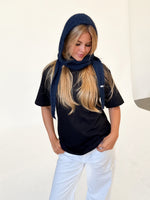 Modelfoto af pige iført navy KATHERINE balaclava, mørkblå t-shirt og hvide NANNA jeans. Alt er fra BySofieSønderby.