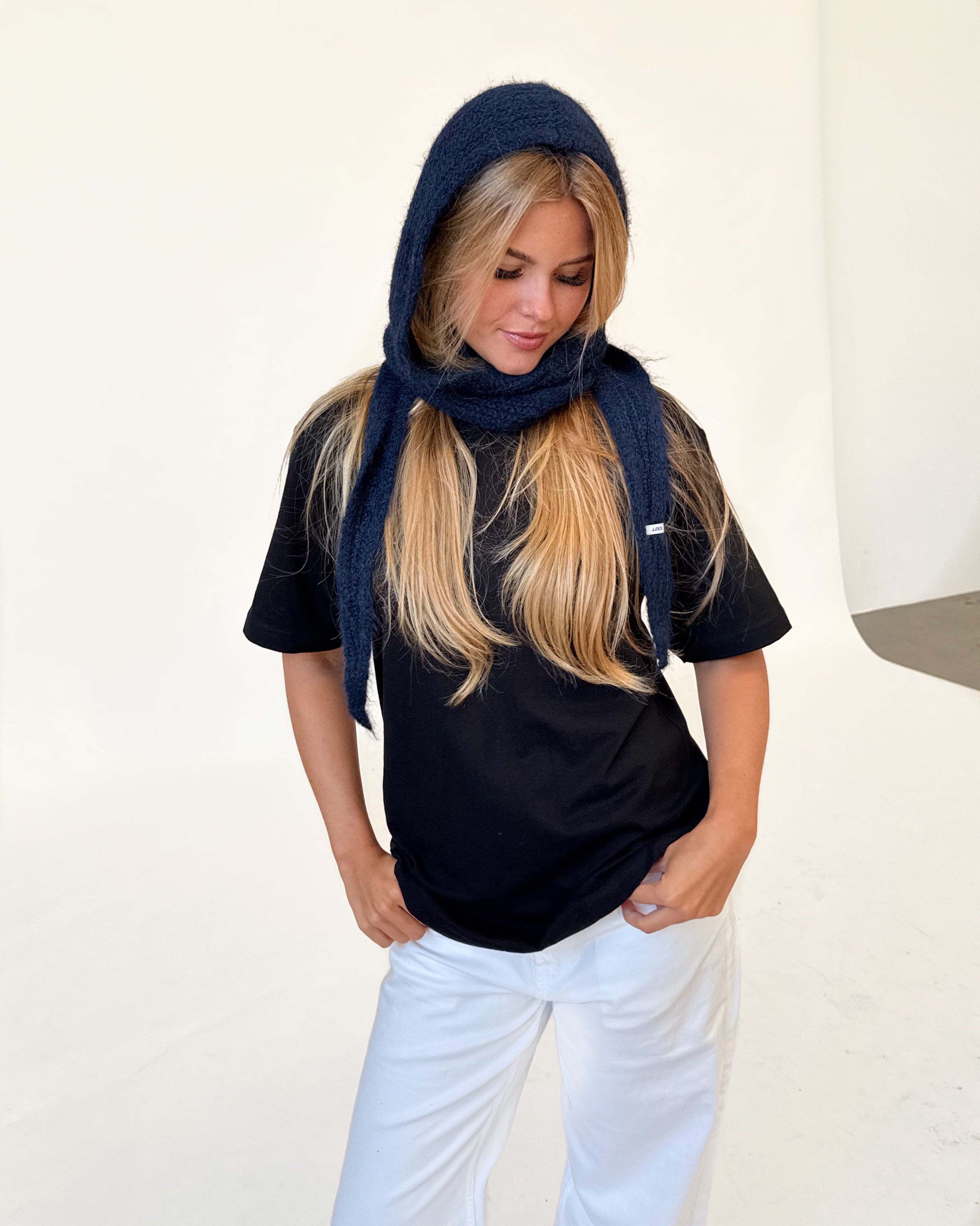 Modelfoto af pige iført navy KATHERINE balaclava, mørkblå t-shirt og hvide NANNA jeans. Alt er fra BySofieSønderby.