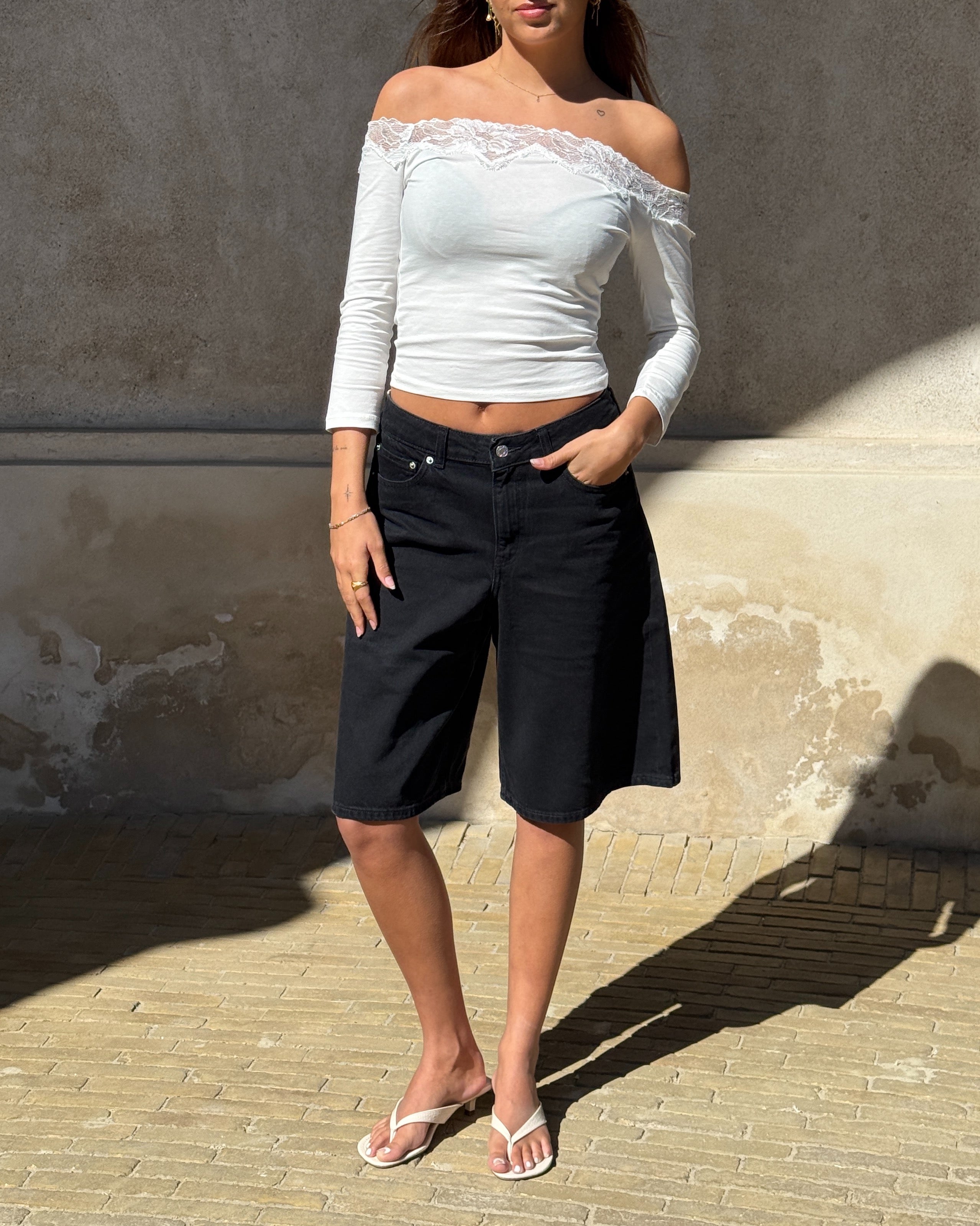 Modelbillede af KINSLEY off shoulder bluse, hvid og TOKYO jorts, sort. Begge fra BySofieSønderby