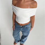 Modelfoto af pige som bærer en Leia top i hvid, samt et par hvide Nanna jeans. Alt fra By Sofie Sønderby