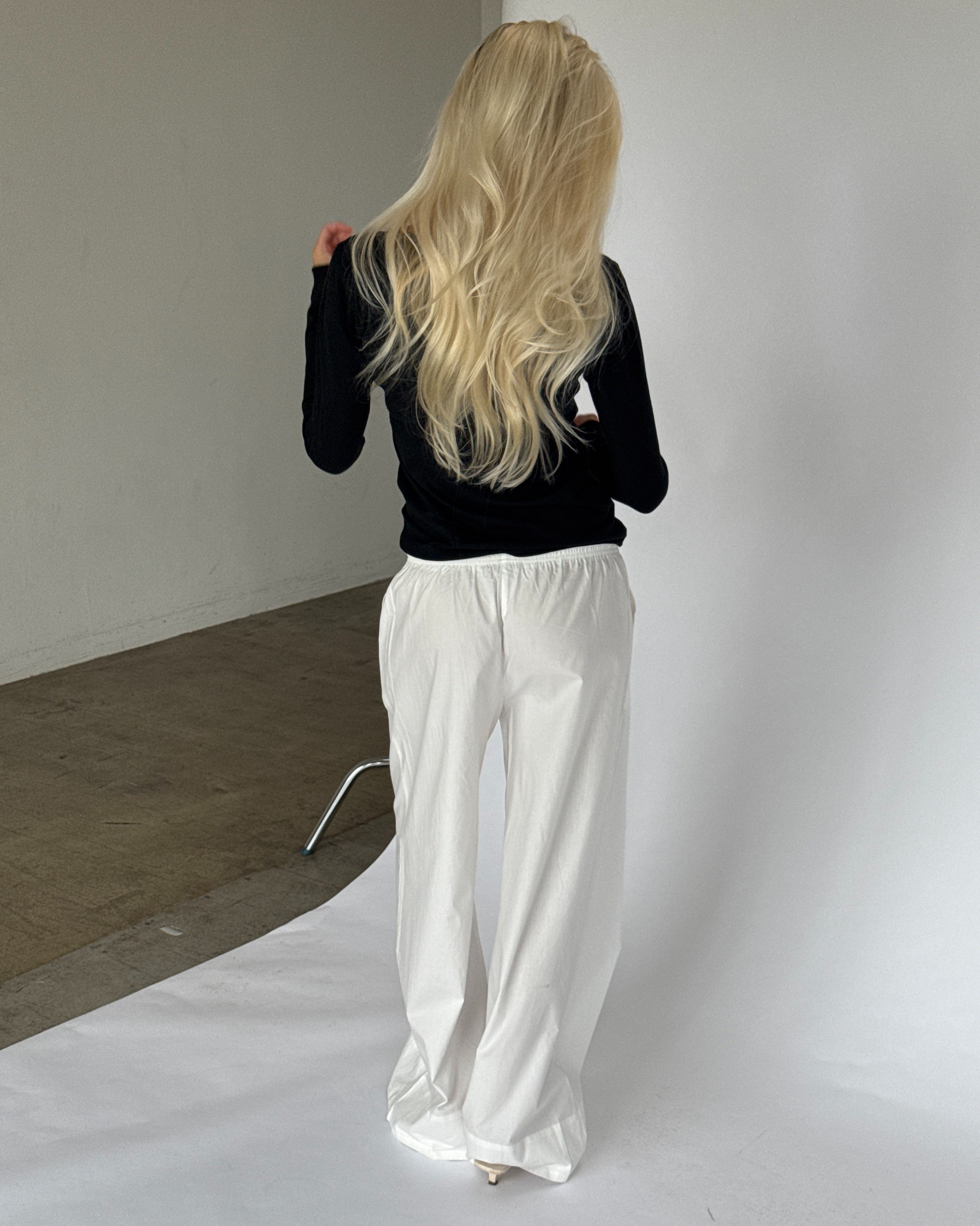 Modelbillede af LILLIE langærmet v-hals, sort og DANIA wide leg bukser, hvid. Begge fra BySofieSønderby