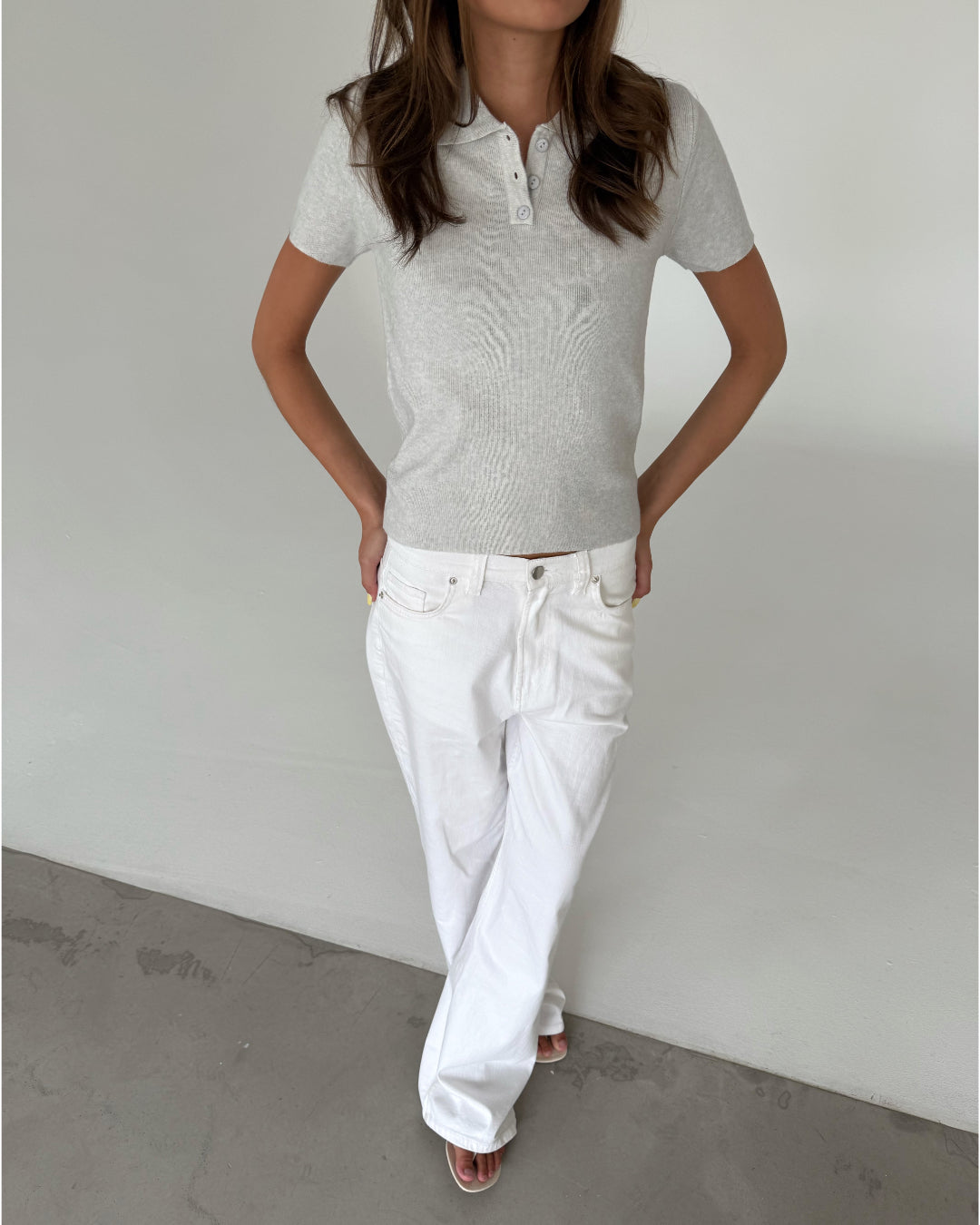 Modelfoto af pige med LILOU polo, grå og NANNA jeans, hvid - begge fra BySofieSønderby