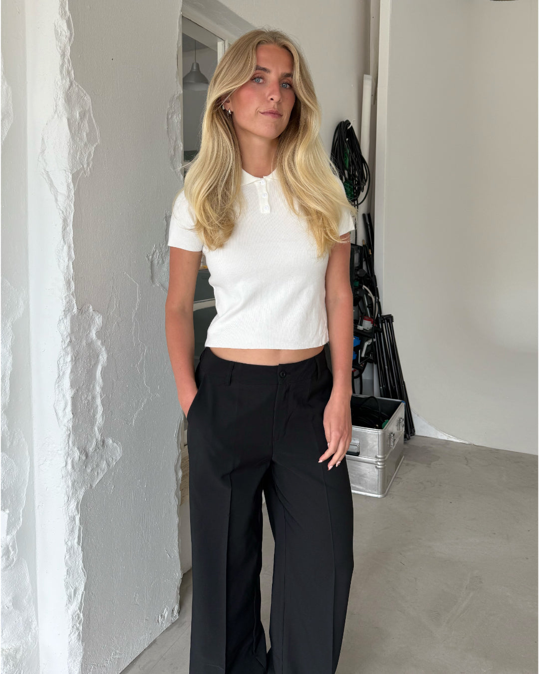 Modelfoto af pige med LILOU polo, hvid og MILAN bukser, sort - begge fra BySofieSønderby