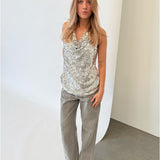 Modelfoto af pige i sølvfarvet LINA top med pailetter, samt grå NANNA jeans. Alt er fra BySofieSønderby.