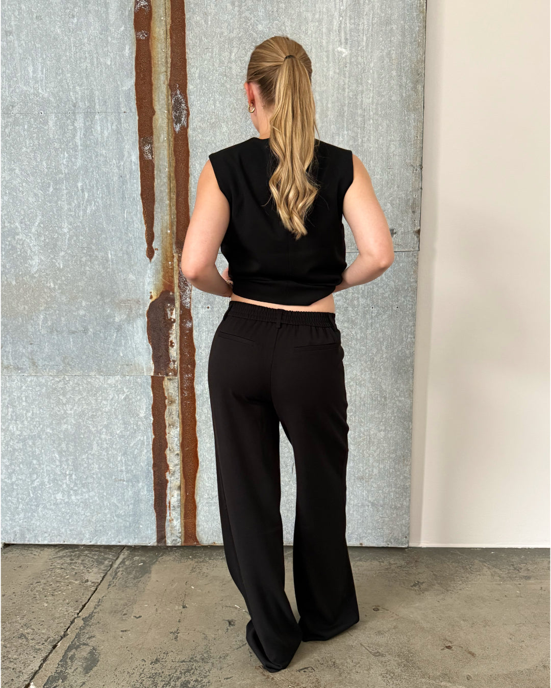 Modelfoto af pige der bærer Lisa bukser i sort, samt sort Lisa vest. Alt fra BySofieSønderby