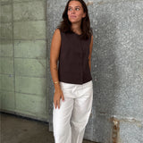 Modelfoto af pige der bærer Lisa vest i brun, samt hvide nanna jeans. Alt fra BySofieSønderby