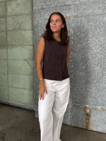 Modelfoto af pige der bærer Lisa vest i brun, samt hvide nanna jeans. Alt fra BySofieSønderby