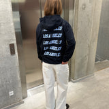 Stemningsbillede af pige der bærer en navy hoodie med blåt LOS ANGELES tryk og hvide NANNA jeans.  Fra BySofieSønderby