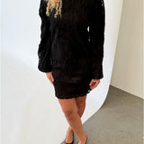 Modelfoto af pige i sort LUCIE kjole, samt sorte sko med hæl. Alt er fra BySofieSønderby.