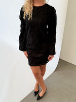 Modelfoto af pige i sort LUCIE kjole, samt sorte sko med hæl. Alt er fra BySofieSønderby.