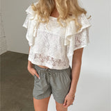 Modelfoto af pige iklædt LUCILLE blonde bluse, hvid og LANA shorts, grøn - begge fra BySofieSønderby