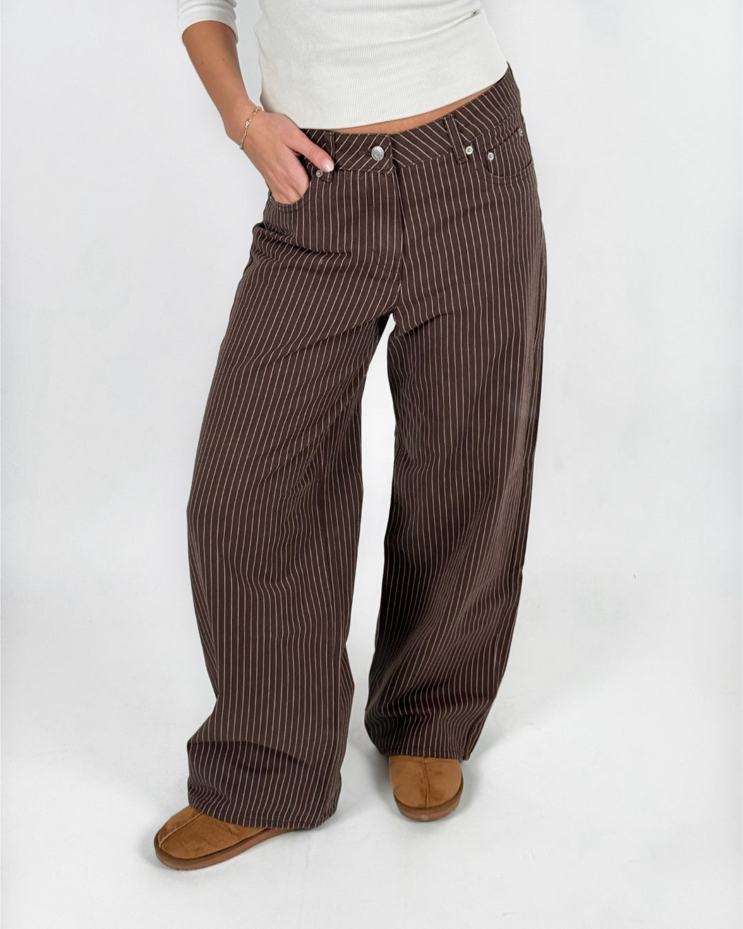 Modelfoto af pige i brun/lyserød MADDY bukser og hvid basic t-shirt. Alt er fra BySofieSønderby.